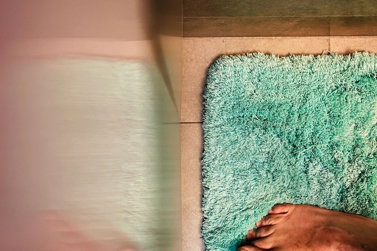 Feet resting on a bathroom mat