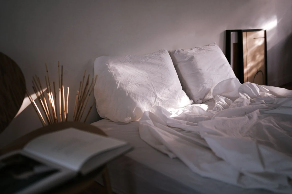 A bed dressed with linen and a duvet