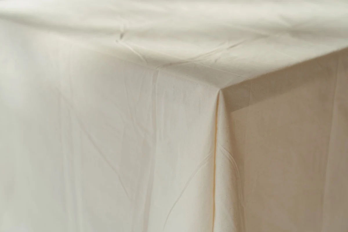 A white tablecloth draped over a wooden table