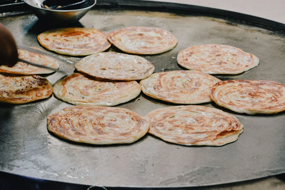 Flatbreads cooking on a wide tawa