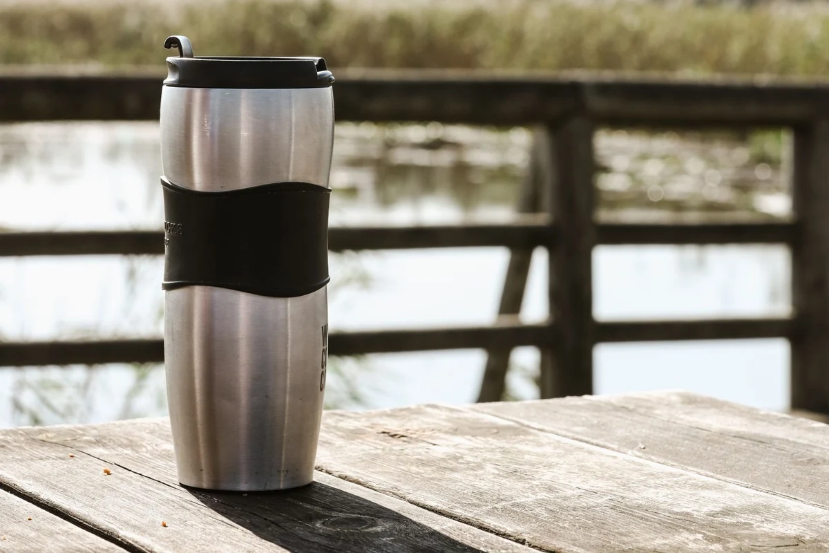 A metal travel mug with a lid
