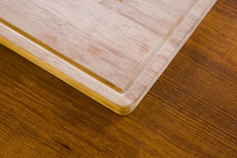 A bamboo chopping board on a wooden surface