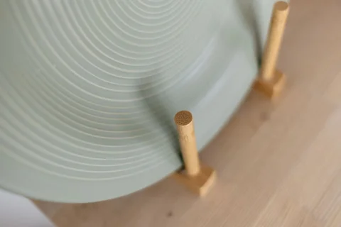 A plate resting in a wooden dish drying rack