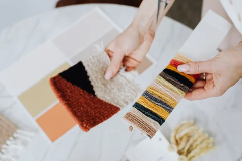 A hand examining textile samples