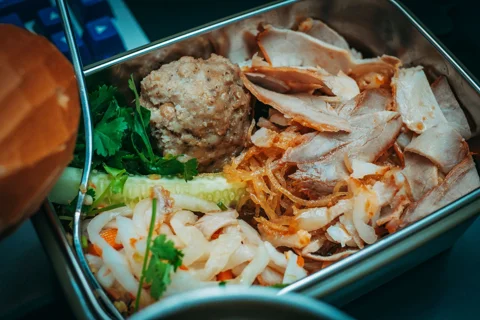 An open metal lunchbox packed with food