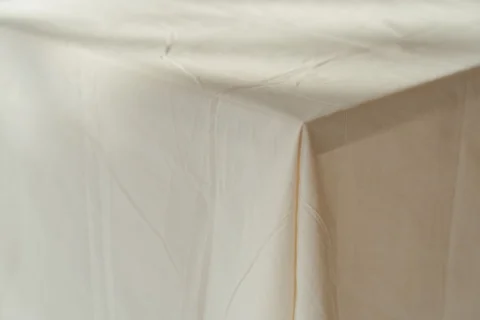 A white tablecloth draped over a wooden table