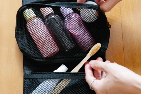 An open toiletry pouch containing small bottles