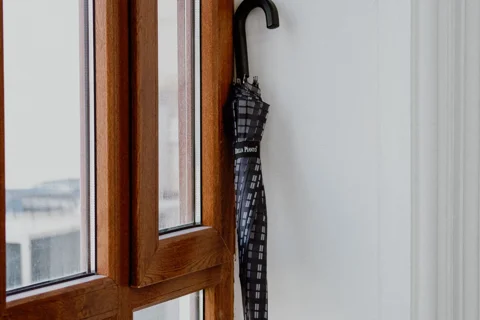 An umbrella resting by a window